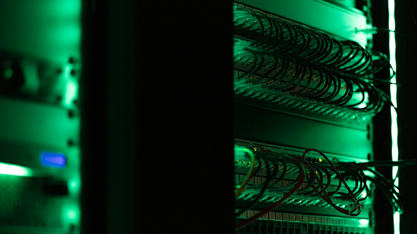 Server racks in a data center with many network cables.